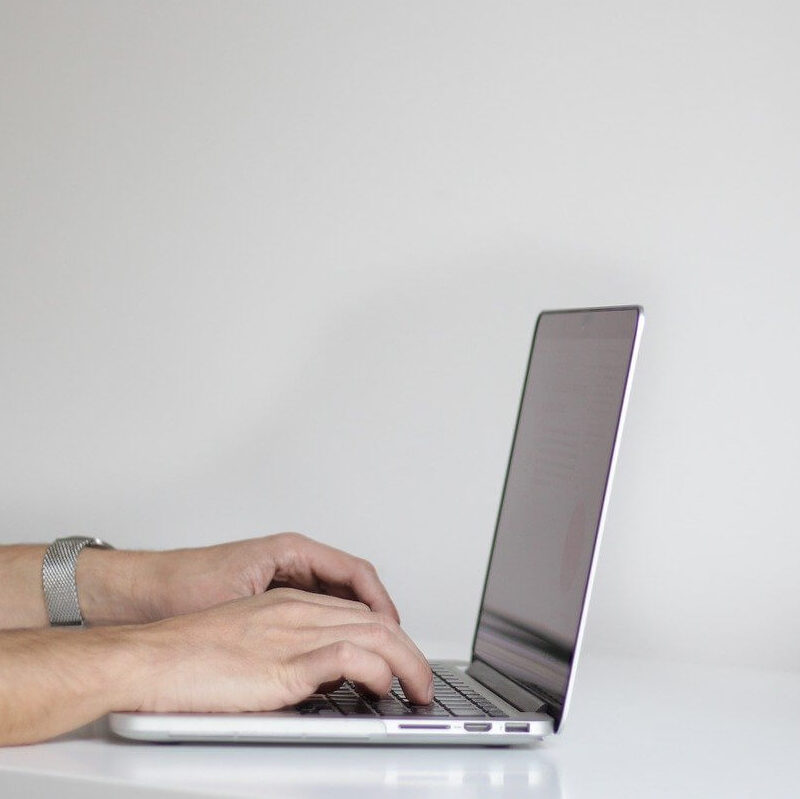 hands writing on laptop